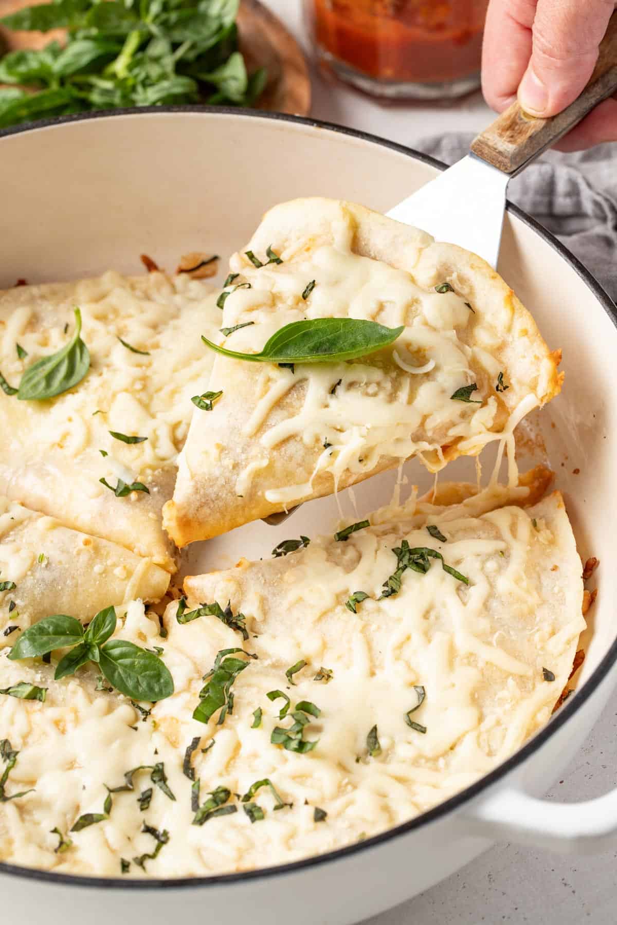 A spatula scooping out a quesadilla slice with melty cheese pulling off of it.