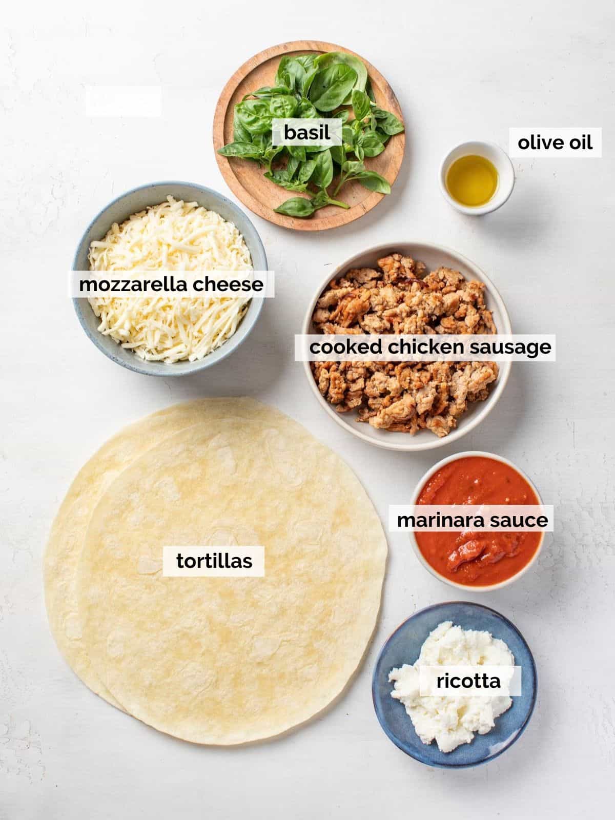 Ingredients for pizza quesadillas on a white background.