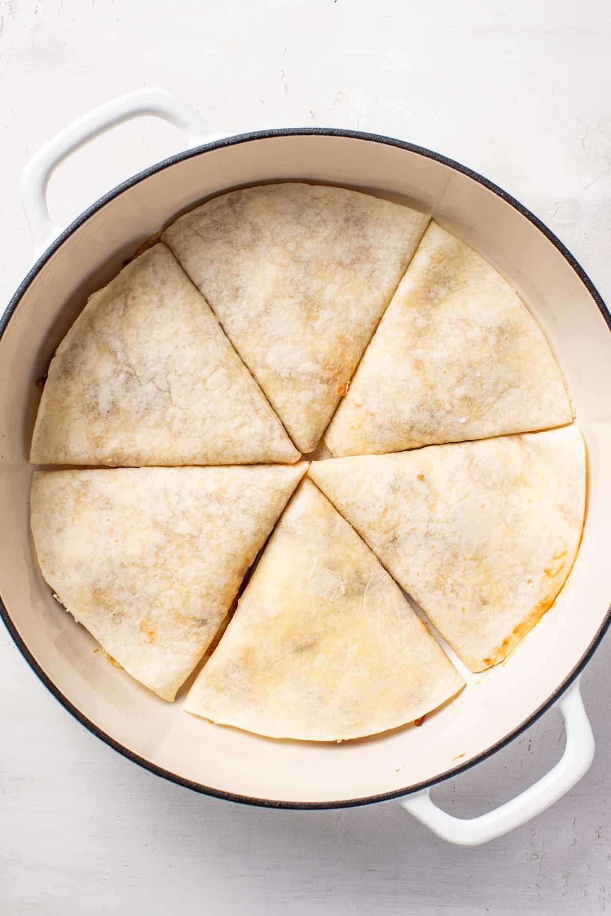 Laying the pizzilla pockets in a single layer in a enameled cast iron pan.